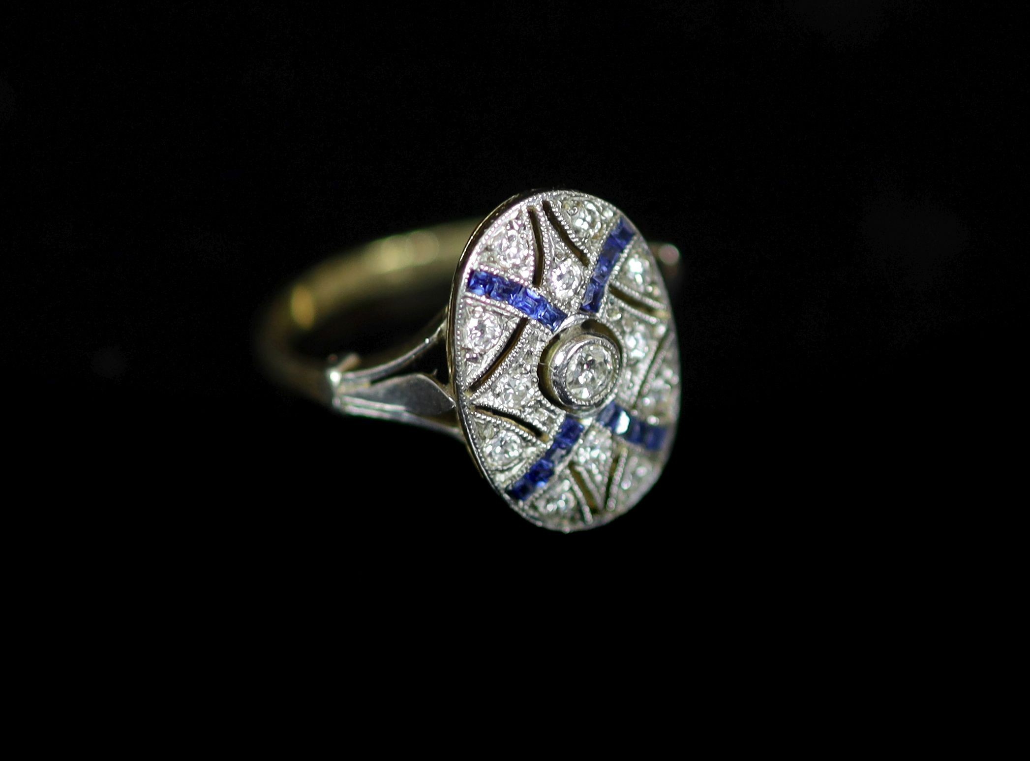 A 1920's gold and platinum, sapphire and diamond millegrain set pierced oval dress ring